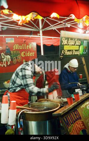 Bath, England - 3. Dezember 2025: Bath Christmas Market, mit Verkaufsständen, Verkaufsständen und Käufern. Aufgenommen nach Einbruch der Dunkelheit auf Spezialfilm. Stockfoto