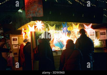 Bath, England - 3. Dezember 2025: Bath Christmas Market, mit Verkaufsständen, Verkaufsständen und Käufern. Aufgenommen nach Einbruch der Dunkelheit auf Spezialfilm. Stockfoto