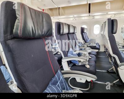 Reihe leerer dunkelblauer Flugzeugsitze (Air France) mit Kopfstützen und Kissen in einem Großraumflugzeug Stockfoto