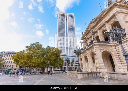 Frankfurt, Deutschland - 21. Oktober 2025: Der moderne Frankfurter Opernturm steht an einem hellen Herbsttag hinter der verzierten Alten Oper. Menschen Stockfoto