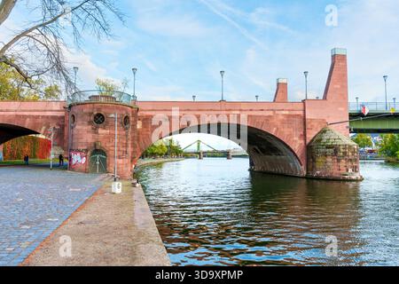 Frankfurt, Deutschland - 21. Oktober 2025: Die Alte Brücke aus rotem Sandstein erhebt sich majestätisch über dem ruhigen Main und spiegelt Schönheit an einem cl wider Stockfoto