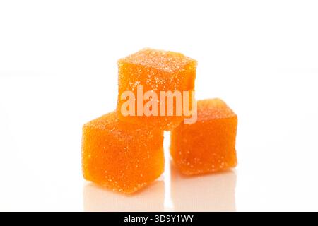 Drei Orangenwürfel Marmelade auf weißem Hintergrund. Die Würfel werden übereinander gestapelt Stockfoto