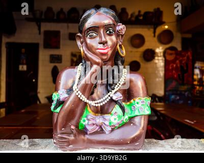 Traditionelle Keramikpuppe in hellen Farben, die die Büste einer afro-brasilianischen Frau zeigt, die aus dem Fenster blickt, Brasilien Stockfoto