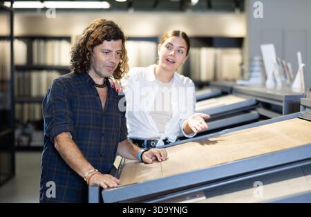 Verheiratetes Paar, das Keramikfliesen für neue Möbel im Baumarkt aussucht Stockfoto
