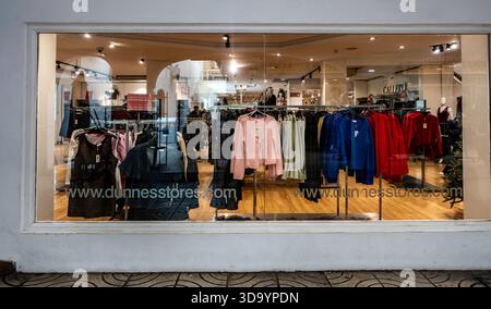 Das Schaufenster eines Dunnes Stores der Bekleidungsbranche in Fuengirola, Spanien, bietet Wintermode für Damen auf Ausstellungsregalen. Stockfoto