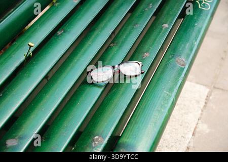 Nynashamn, Stockholmer County, Schweden - 29. Mai 2025: Eine Brille sitzt auf einer grünen Bank. Die Bank ist leer und die Gläser sind die einzige Obj Stockfoto