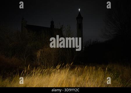 Warschau, Polen. Dezember 2025. Ein beleuchtetes Kreuz befindet sich auf dem katholischen Heiligtum der Jungfrau Maria Kirche in Warschau, Polen am 2025. Dezember. (Foto: Jaap Arriens/SIPA USA) Credit: SIPA USA/Alamy Live News Stockfoto