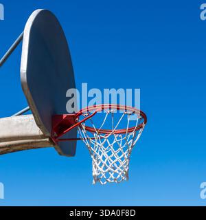 Ein Basketballnetz im Freien und ein Rückenbrett vor einem blauen wolkenlosen Himmel. Stockfoto
