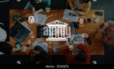 Ein vielseitiges Team von Fachleuten arbeitet an einem Holztisch zusammen, analysiert Diagramme und diskutiert Strategien in einer modernen Büroumgebung mit Stockfoto