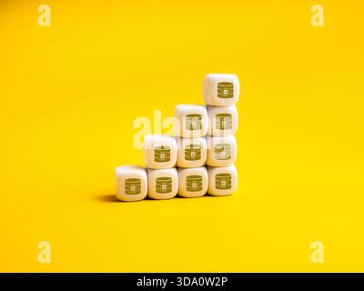 KI-Datensymbole auf weißem Würfel, die als Diagrammschritte auf gelbem Hintergrund gestapelt sind, stellen ein schnelles Wachstum von Daten aus künstlicher Intelligenz, eine Erweiterung des Rechenzentrums, Stockfoto