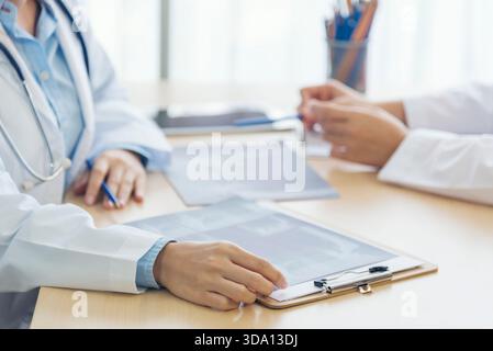 Zwei asiatische Frauen Hand Ärzte Treffen schreiben verschreibungspflichtige medizinische Klinik. Arzt besprich mit dem Laptop einen schriftlichen Hinweis. Nahhände von zwei Frauen, Doktor med Stockfoto
