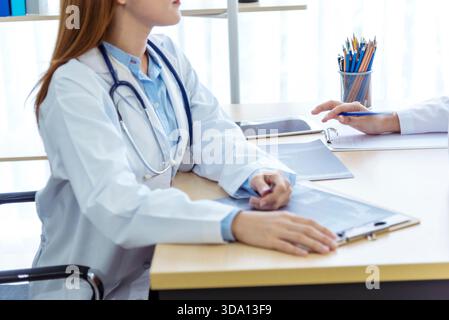 Zwei asiatische Ärztinnen diskutieren Treffen Arztpraxis medizinische Klinik schauen Röntgenfilm Beratung Patienten Krankheit. Asiatisches medizinisches Labor junge Frauen ta Stockfoto