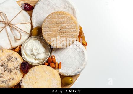 Käseplatte mit verschiedenen Käsesorten und Beilagen auf einem Holzbrett Stockfoto