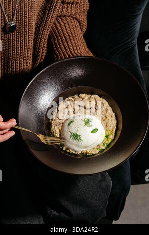 Risotto mit Pilzen auf einer schwarzen Platte Stockfoto