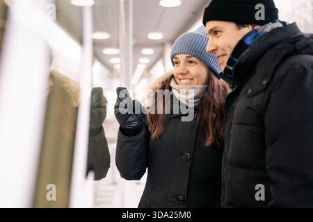 Ein paar Schaufensterbummel und Blick auf den Winter. Weihnachtsgeschenk oder -Schmuck. Frau und Mann. Glückliche Menschen. Luxusgeschäft. Jubiläumsgeschenk. Stockfoto
