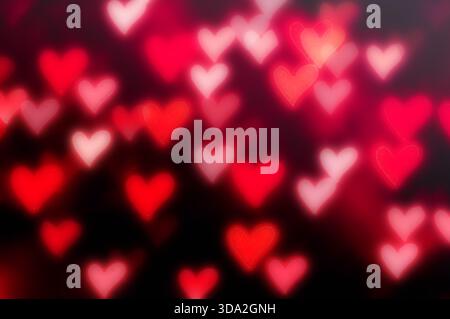 Rotes Herz-Bokeh-Hintergrund am Valentinstag mit defokussierten hellen Herzen, Valentinstag-Symbol Stockfoto
