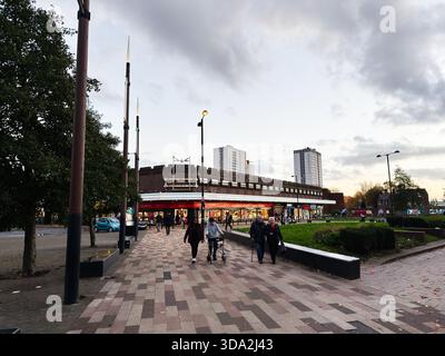Salford, Vereinigtes Königreich - 8. November 2025: Die Menschen spazieren an Geschäften und urbanen Landschaften in einer belebten Salford Street Szene vorbei. Stockfoto