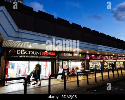 Salford, Großbritannien - 8. November 2025: Geschäftige Einkaufsstraße in Salford mit einem Discounter, Restaurants und Abendgästen. Stockfoto