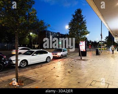 Salford, Großbritannien - 8. November 2025: Abendliche Szene in Salford mit Verkehr, Fußgängern und Bus entlang einer beleuchteten Stadtstraße. Stockfoto