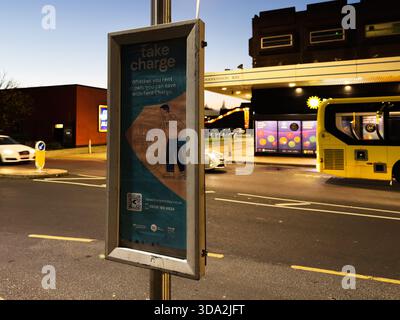 Salford, Großbritannien - 08. November 2025: Abendliche Straßenszene in Salford zeigt an einer Bushaltestelle ein Take Charge-Poster. Stockfoto