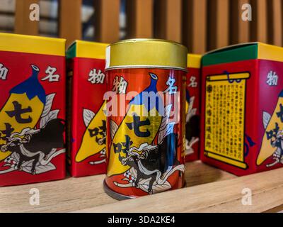 Die rot-goldene Dose mit einem großen Chilidesign und dem Zenkoji-Tempel auf der Rückseite ist seit Jahrzehnten unverändert geblieben. Nur in Nagano ist die Version mit einem laufenden Bullen mit einem Tuch an den Hörnern erhältlich. Nagano, Präfektur Nagano, Japan Stockfoto