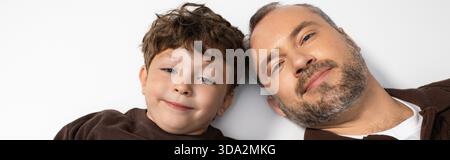 Ein liebevoller Vater und sein verspielter Sohn teilen einen warmen, freudigen Moment zusammen. Stockfoto