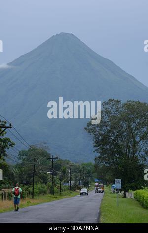 Vulkan Arenal erhebt sich an einem bewölkten Tag über dem Arenal-See, umgeben von üppiger Vegetation und sanftem Licht im Norden Costa Ricas. Stockfoto
