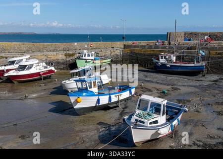 Slade, Irland-September 2025; Fischerhafen auf der Hook Peninsula mit Fischerbooten, die bei Ebbe auf dem Schlammrutsch im für SLA bekannten Hafen geerdet sind Stockfoto