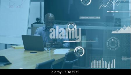 Mann in hellblauem Hemd überprüft Telefon und überprüft Laptop im Besprechungsraum mit Papieren Stockfoto