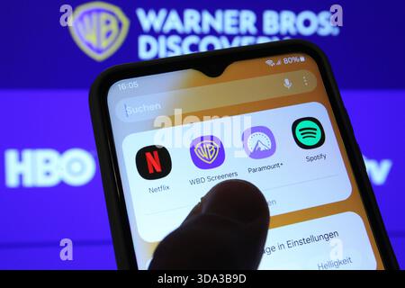 Auf einem Laptop wurde die Website vom Hollywood-Konzern Warner Bros. Discovery aufgerufen. Davor sind auf einem Smartphone die Apps der Paramount Pictures Corporation von Netflix und Warner Bros. Discovery zu sehen. Netflix und Paramount wollen Warner Bros. Discovery übernehmen. Symbolbild/Symbolfoto. Schnelsen Hamburg *** die Website der Hollywood-Gruppe Warner Bros Discovery wurde auf einem Laptop davor aufgerufen, die Apps der Paramount Pictures Corporation von Netflix und Warner Bros Discovery sind auf einem Smartphone zu sehen Netflix und Paramount will Warner Bros Discovery Sym übernehmen Stockfoto