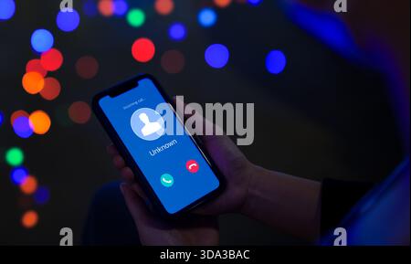 Frau, die ein Mobiltelefon hält und einen Anruf von einem unbekannten Anrufer eingeht. Betrüger oder Fremder, Betrüger mit gefälschter Identität, Streich-Anrufer, anonym, Fr. Stockfoto