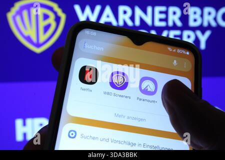 Auf einem Laptop wurde die Website vom Hollywood-Konzern Warner Bros. Discovery aufgerufen. Davor sind auf einem Smartphone die Apps der Paramount Pictures Corporation von Netflix und Warner Bros. Discovery zu sehen. Netflix und Paramount wollen Warner Bros. Discovery übernehmen. Symbolbild/Symbolfoto. Schnelsen Hamburg *** die Website der Hollywood-Gruppe Warner Bros Discovery wurde auf einem Laptop davor aufgerufen, die Apps der Paramount Pictures Corporation von Netflix und Warner Bros Discovery sind auf einem Smartphone zu sehen Netflix und Paramount will Warner Bros Discovery Sym übernehmen Stockfoto