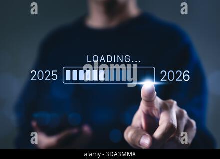 Fortschritt und Übergang von 2025 auf 2026 Konzept. Eine Person, die auf den Ladebalken zeigt, der von 2025 auf 2026 wechselt, Fortschritte, Zukunftsplanung, Stockfoto