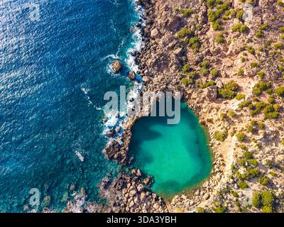Aus der Vogelperspektive auf einen kleinen Meereskrater umgeben von Felsen, Voulolimni, Kreta, Griechenland Stockfoto