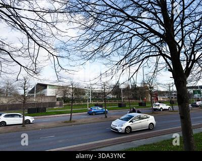 Manchester, Großbritannien - 16. November 2025: Stadtblick in Manchester mit Autos und blattlosen Bäumen. Stockfoto