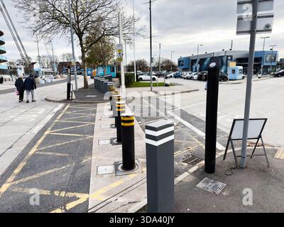 Manchester, Großbritannien - 16. November 2025: Straßenszene im City of Manchester Stadium mit Fußgängern, Autos und Pollern. Stockfoto