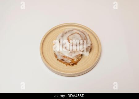 Zimtrollen gefüllt mit Schokolade und Haselnüssen, wo die Schokolade schmilzt und zu einem flüssigen Zentrum wird, bestreut mit gehackten gerösteten Haselnüssen Stockfoto
