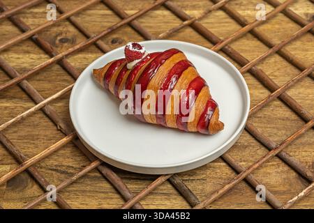 Eine Auswahl an Croissants, darunter einfache, Mandel- und Schokoladensorten, in einem Brotkorb mit einer Leinenserviette angeordnet Stockfoto