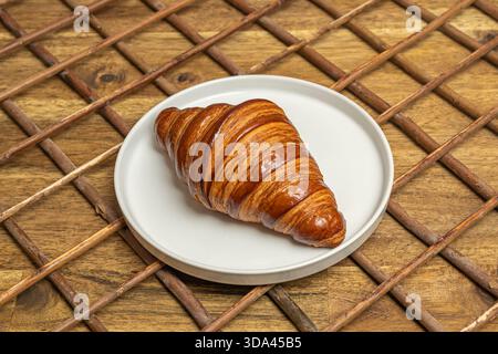 Eine Auswahl an Croissants, darunter einfache, Mandel- und Schokoladensorten, in einem Brotkorb mit einer Leinenserviette angeordnet Stockfoto
