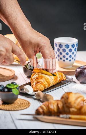 Croissant gefüllt mit Nougateis, getaucht in dunkle Schokolade, dekoriert mit Mandelsplittern – ein vom Croissant inspiriertes gefrorenes Dessert. Stockfoto