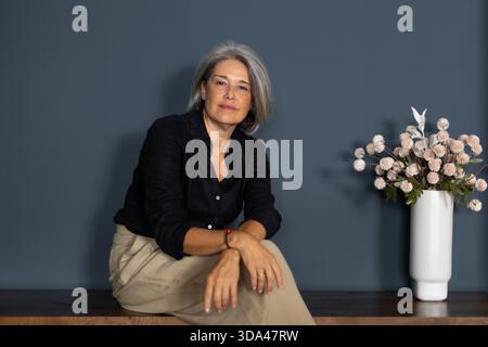 Porträt einer selbstbewussten, Reifen Geschäftsfrau, die in einem modernen Büro auf einer Bank sitzt und Professionalität und Erfolg ausstrahlt Stockfoto