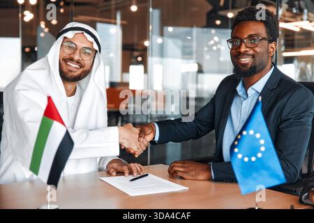 Die Flaggen der Europäischen Union und der VAE stehen während der Verhandlungen zwischen Diplomaten und Geschäftsleuten auf dem Tisch. Die Vertreter erörtern die Beziehungen Stockfoto