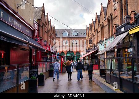 Menschen, die in Dublin, Irland, am 8. August 2025 in einer städtischen Straße mit Geschäften und Restaurants spazieren Stockfoto