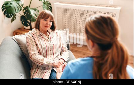 Glückliche junge weibliche Krankenschwester bieten Pflege medizinischen Service Hilfe Unterstützung lächelnde reife Frau bei häuslichen medizinischen Besuch, Dame Pfleger Doktor geben Empathie enco Stockfoto