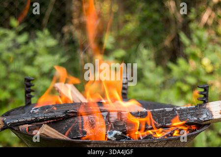 Feuer brennt in einem Barbecue Nahaufnahme an einem sonnigen Tag. Stockfoto