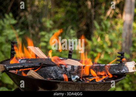 Feuer brennt in einem Barbecue Nahaufnahme an einem sonnigen Tag. Stockfoto