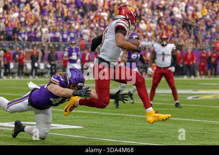 Washington Commanders Quarterback Jayden Daniels (5) springt am 7. Dezember 2025 im US Bank Stadium in Minneapolis Minnesota am Linebacker Andrew Van Ginkel (43) vorbei an Minnesota Vikings. Die Minnesota Vikings besiegten die Washington Commanders 31-0 (Jeff Scudder / Image of Sport) Stockfoto