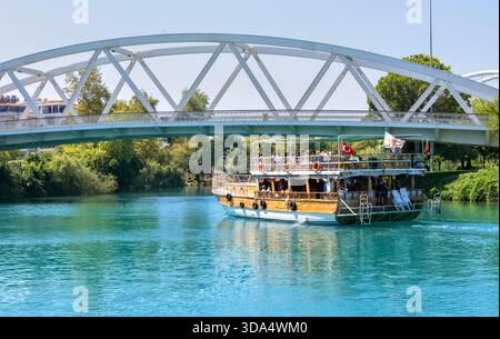 Ausflugsboot, das unter der Brücke über den Fluss Manavgat, Antalya Türkei fährt Stockfoto