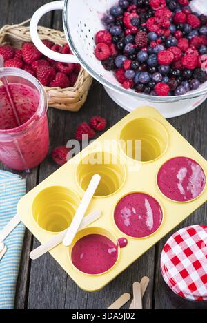 Eisformen mit hausgemachtem Saft aus Beerenfrüchten füllen Stockfoto