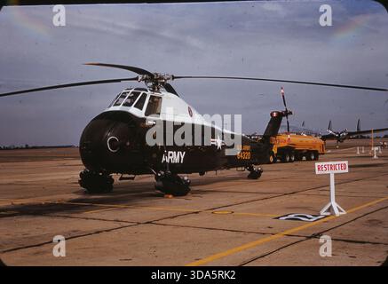 Ein Heer Sikorsky H-34 Seahorse auf der Spence Air Base, Moultrie, GA, im Januar 1959. Dieser Helikopter wurde als Teil der Begleitung und des Transports während eines Besuchs von Präsident Eisenhower eingesetzt. Das Präsidentenflugzeug Columbine III ist im Hintergrund zu sehen. Stockfoto